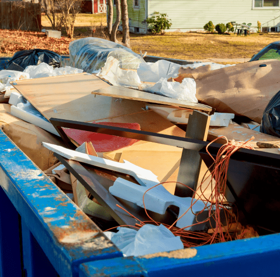 junk removal of a house inside of a blue dumpster